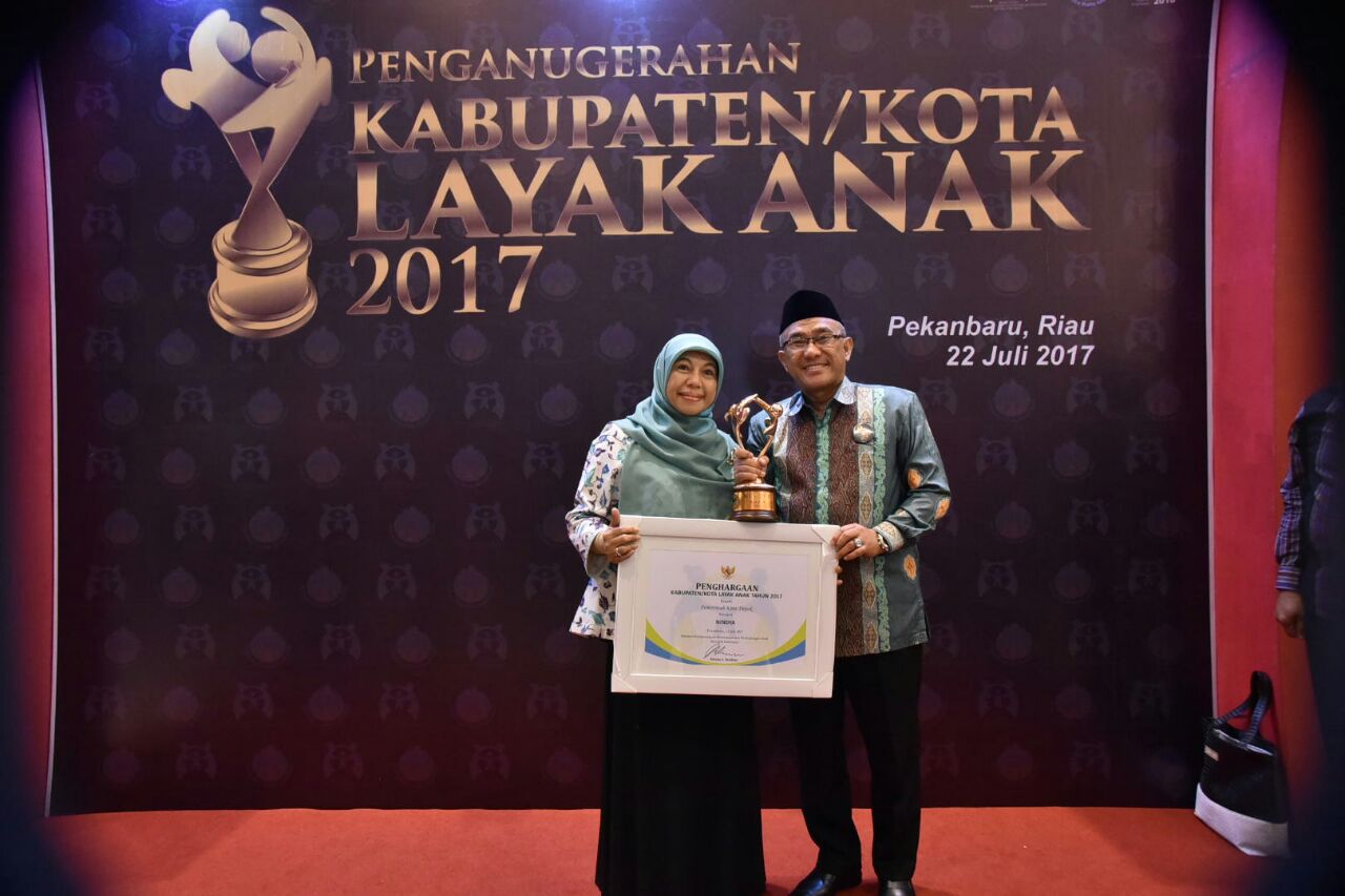 Walikota Depok Mohammad Idris bersama Bunda Elly Farida berfoto dengan penghargaan Kota Layak Anak. 
