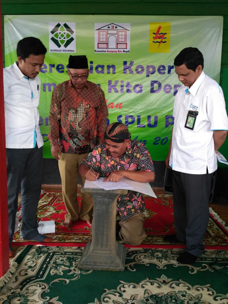 Ketua Dewan Pembina Komunitas Kampung Kita Depok Bowo sedang menandatangani berita acara penyerahan SPLU bersama Manager PLN Area Depok. 