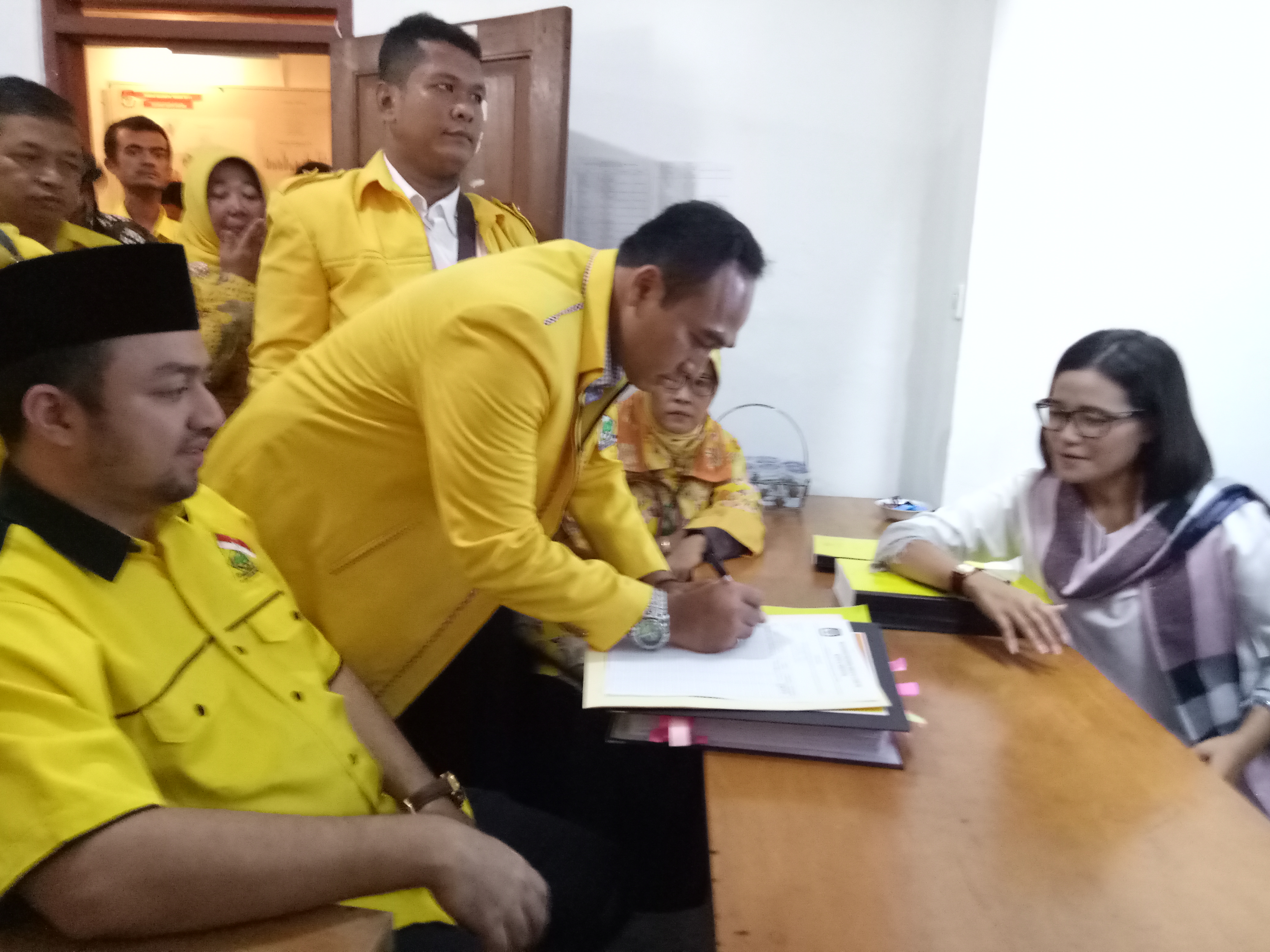 Sekjen DPD Partai Golkar Depok Dindin Saprudin menandatangani berkas serahterima berkas disaksikan Ketua DPD Partai Golkar Farabi A. Rafiq dan Ketua KPUD Depok Titik Nurhayati. 